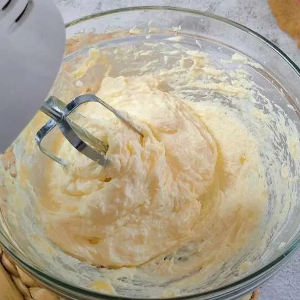 Mixer cream cheese dan gula hingga tercampur merata.