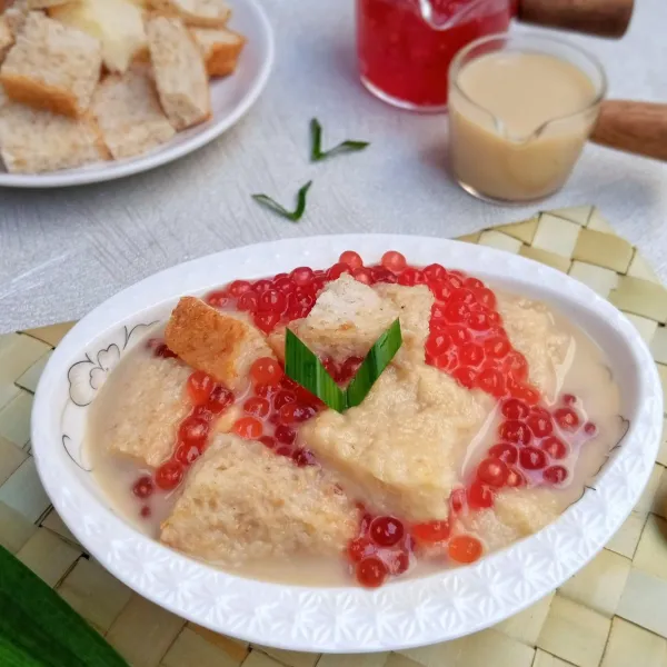 Tata di piring potongan roti tawar dan roti gandum, tambahkan sagu mutiara di atasnya lalu siram dengan kuah sekoteng. Sekoteng siap dinikmati.