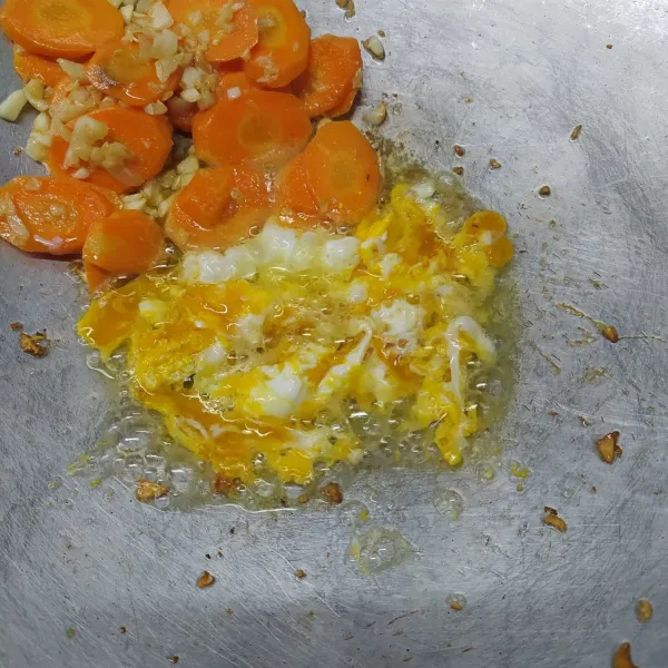 Masukkan wortel, tumis sampai layu. Sisihkan di tepi wajan. Masukkan kocokan telur, bikin orak arik telur.