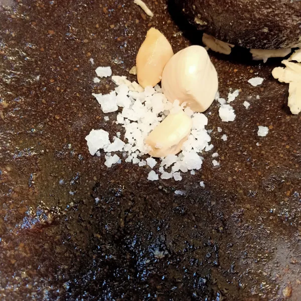 Uleg bawang putih, jahe, dan garam sampai halus.