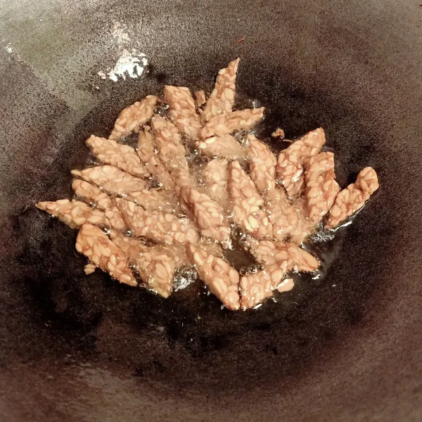 Sambil menunggu merebus daging, goreng tempe hingga berwarna keemasan dan garing. Sisihkan.