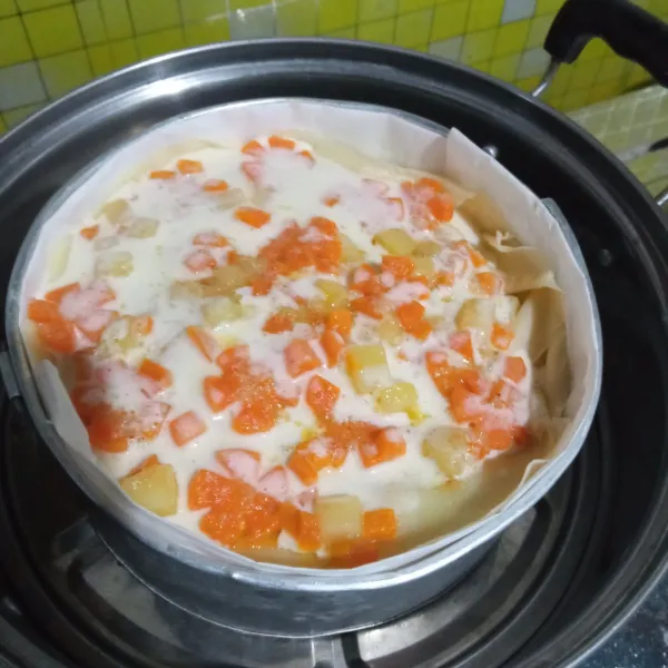 Terakhir, untuk bagian atas beri dan susun topping wortel yang berbentuk bunga dan kentang, siram dengan adonan saus santan yang sudah dicampur rata. Kukus selama ±20 menit.