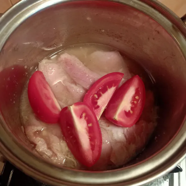 Masukkan daging ke dalam panci. Tambahkan air lalu masukkan tomat. Masak daging sampai empuk.