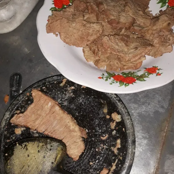 Setelah daging empuk, angkat kemudian pukul-pukul daging sampai  melebar dan agak pipih.