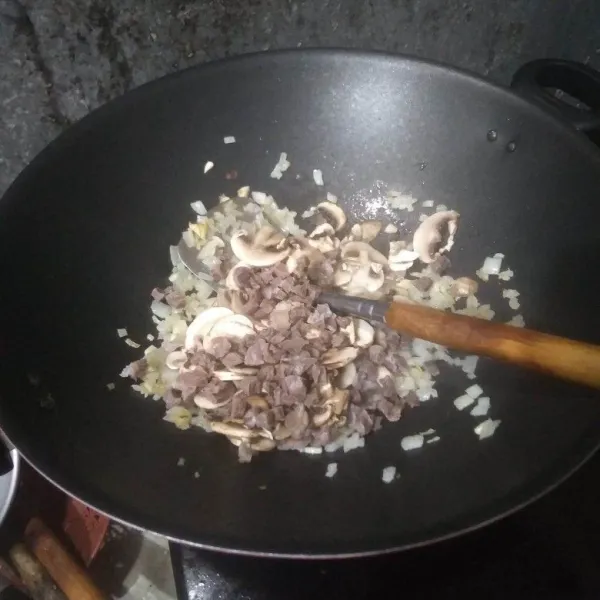 Tumis bawang putih dan bawang bombay hingga harum, masukkan daging sapi cincang dan jamur kancing. Aduk rata.