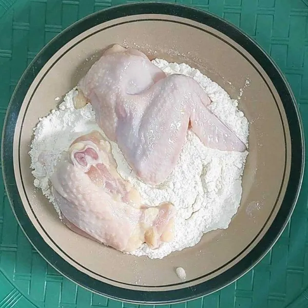 Angkat daging ayam dari tepung basah, lalu masukkan ke dalam tepung kering.