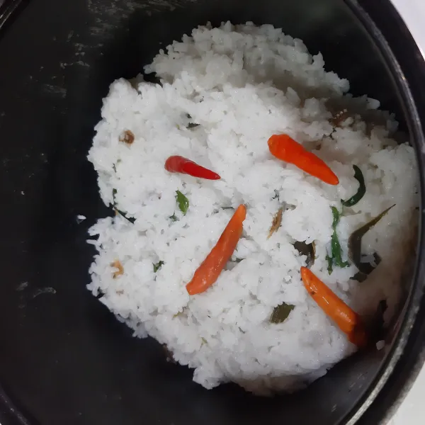 Setelah posisi tombol menjadi WARM, cek nasi bekepor, koreksi rasanya. Sajikan hangat bersama pelengkapnya.
