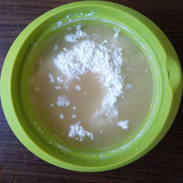 Ketika larutan gula sudah hangat kuku, masukkan ke dalam campuran tepung.