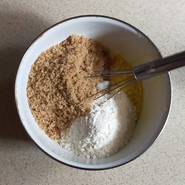 Tuang tepung terigu, baking powder, vanili bubuk dan kelapa sangrai yang sudah halus.