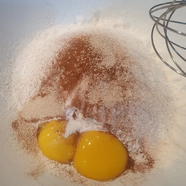 Dalam wadah, campur tepung terigu, telur, kayu manis bubuk, ragi. Siram dengan sirup gula merah. Uleni.