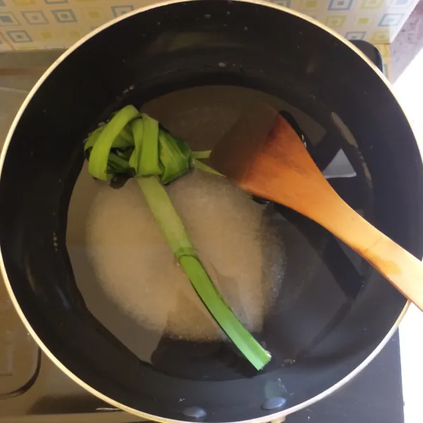 Siapkan panci, masukkan air, gula pasir dan daun pandan. Masak hingga gula larut.