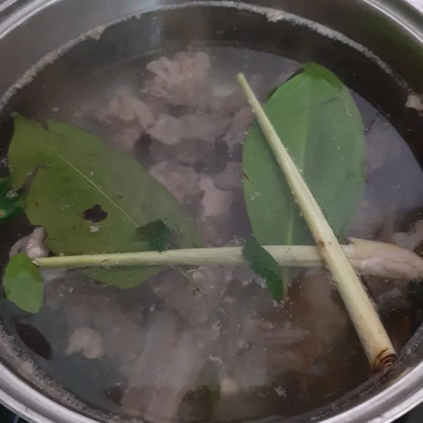 Didihkan air bersih yang kedua. Rebus iga kambing, daun salam, daun jeruk dan serai hingga daging iga empuk.