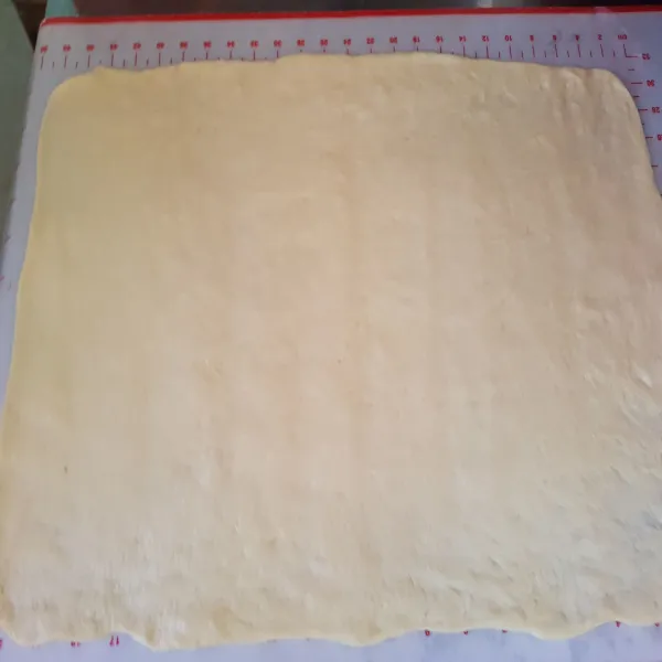 Oleskan butter suhu ruang pada adonan sampai rata lalu bagi adonan menjadi 4 bagian dan tumpuk adonan menjadi 1.