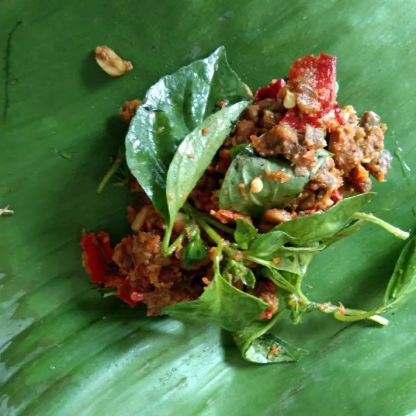 Siapkan daun pisang, tuang sambal oncom secukupnya.