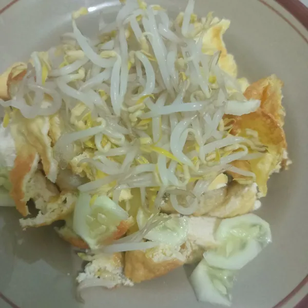 Potong-potong lontong, tahu, kentang, kecambah, dan timun di atas piring, lalu tambahkan kecambah dan tuang bumbu kacang petis yang telah di haluskan.