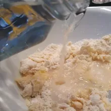 Masukkan air sedikit demi sedikit hingga adonan tampak kental.