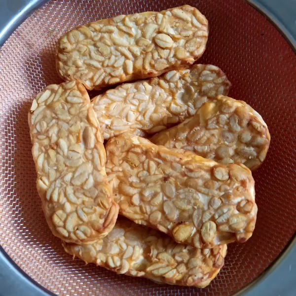 Potong-potong tempe, kemudian marinasi dengan bumbu dan goreng. Setelah itu, tiriskan.