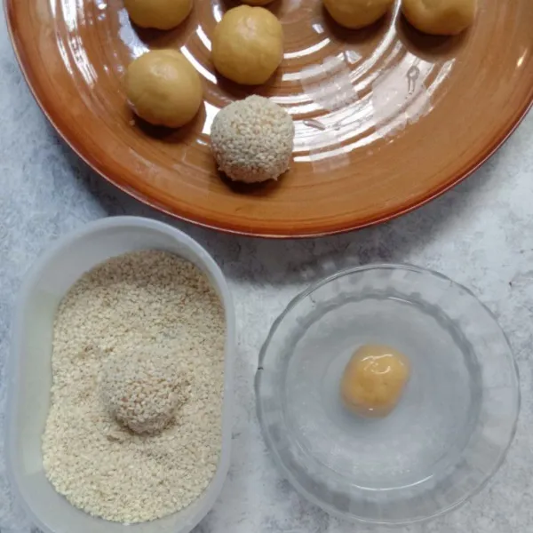 Celupkan adonan ke air kemudian ke wijen