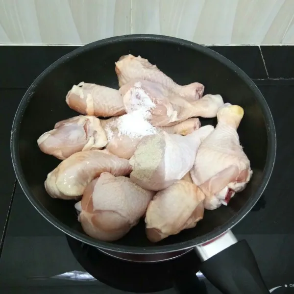 Cuci bersih ayam, lalu masukkan ke dalam wajan. Tambahkan garam dan merica bubuk.