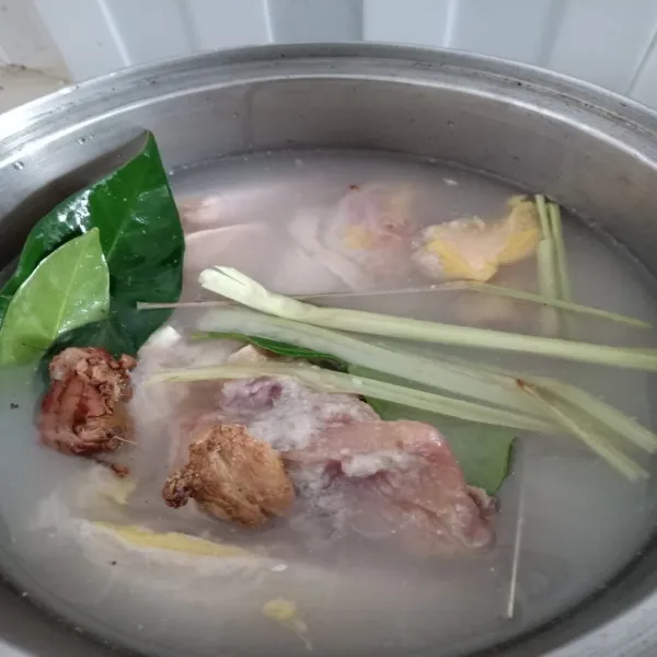 Setelah 1 jam, rebus ayam bersama bumbu dan air kelapa. Tambahkan daun salam, daun jeruk, sereh, jahe dan lengkuas. Aduk rata dan masak hingga air menyusut dan ayam empuk serta matang.