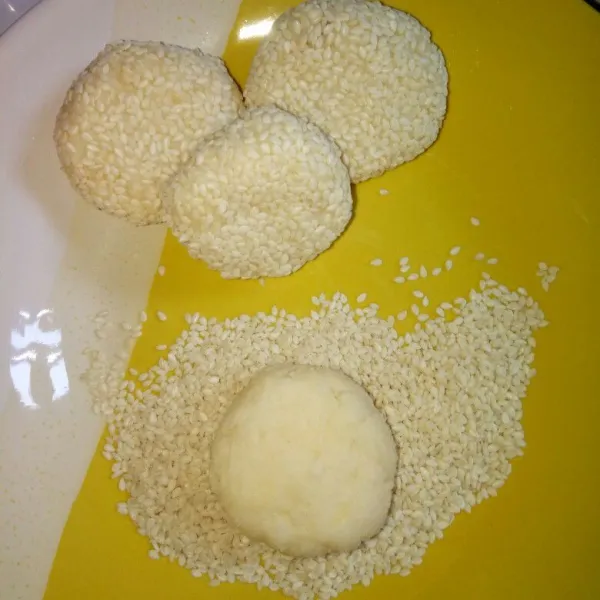 Siapkan wijen untuk baluran. Bentuk adonan tape sesuai selera lalu gulingkan ke wadah wijen sampai merata