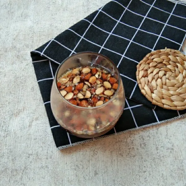 Beri irisan kacang almond pada air jahe, sajikan