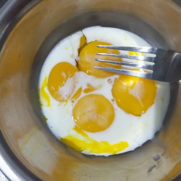 Campur kuning telur dengan susu cair. Aduk pakai garpu saja.