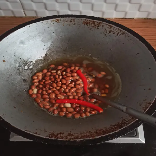 Goreng kacang tanah dengan api kecil hingga kecoklatan dan matang. Goreng juga cabai, angkat cabai jika sudah matang.