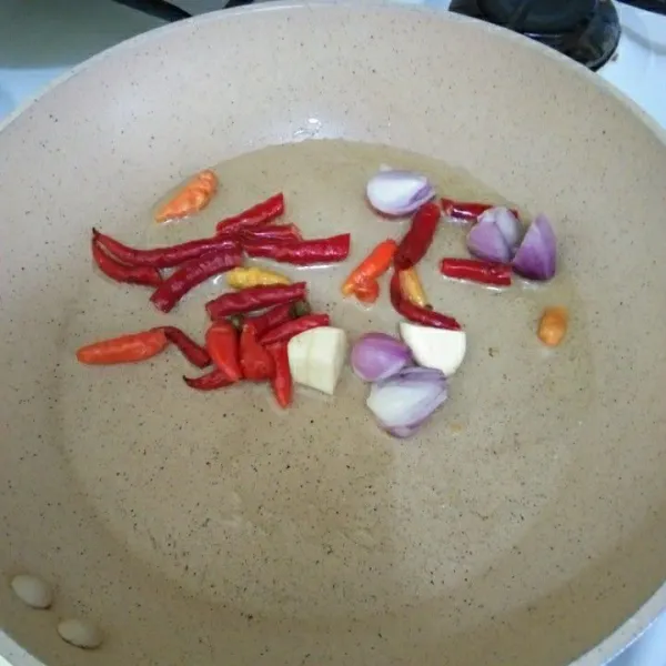 Goreng sebentar bahan sambal seperti bawang merah, bawang putih, cabai rawit dan cabai merah keriting.