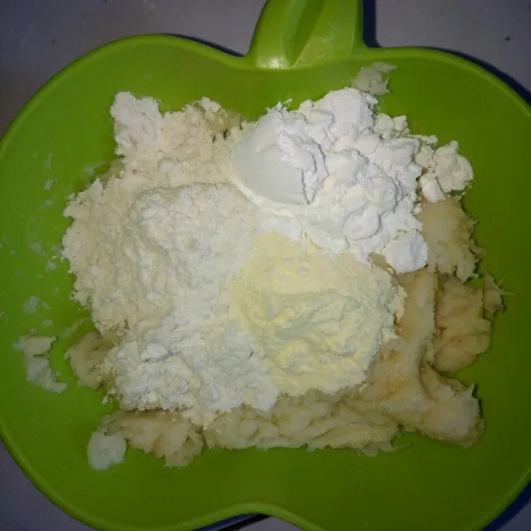 Setelah halus, campurkan terigu, tapioka dan susu bubuk. Aduk raya sampai bisa dibentuk