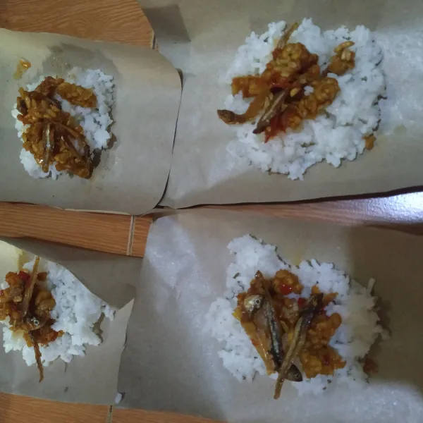 Siapkan kertas nasi, isi dengan nasi & sambal teri tempe, bungkus