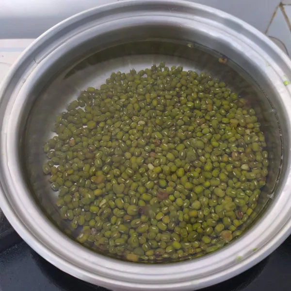 Rebus kacang hijau sampai empuk, siram dengan air dingin, tiriskan dan sisihkan.