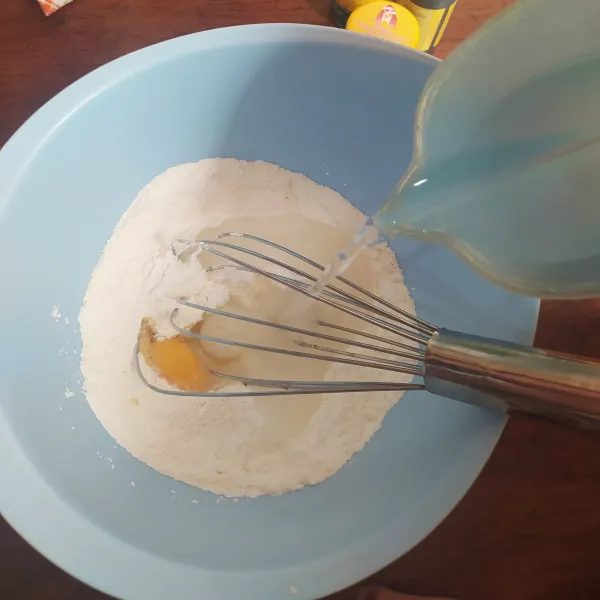 Masukkan telur dan air sambil dikocok dengan whisker.
