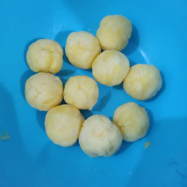 Bentuk bulat-bulat lalu pipihkan, isi dengan irisan gula merah, lalu bulatkan kembali