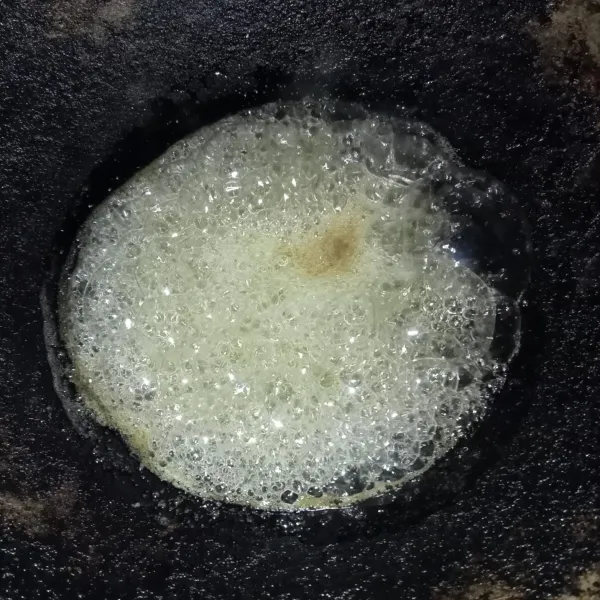 Membuat gula besta, masak gula pasir dan air hingga gula larut dan berbusa.