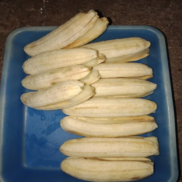 Kupas pisang, belah pisang jangan sampai ujung, kemudian masukkan keju mozarella yang telah dipotong-potong ke dalam belahan pisang