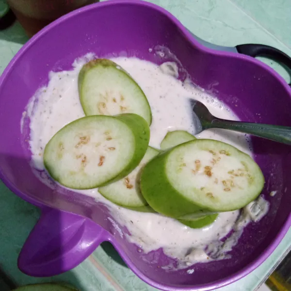 Iris tempe, celupkan dalam tepung bumbu yang telah dicampur dengan air.