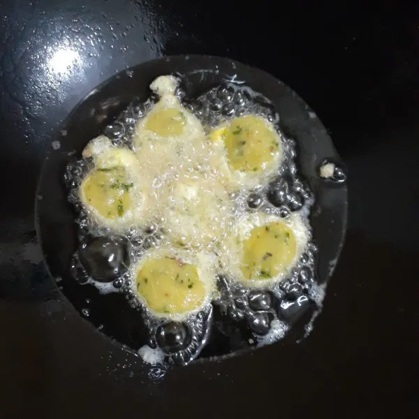 Panaskan minyak sayur di wajan, goreng bulatan kentang sampai kuning kecoklatan. 
Angkat dan tiriskan.