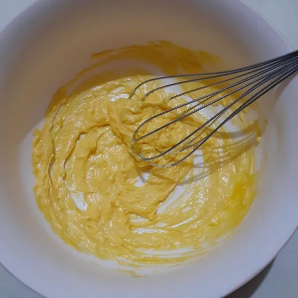 Siapkan wadah, campur kuning telur dan mentega, aduk dengan whisk sampai creamy.