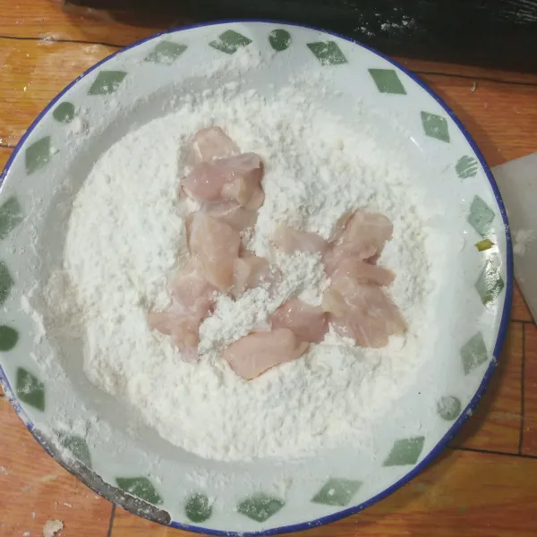 Ambil ayam dari bumbu marinasi, kemudian gulingkan pada tepung. Remas-remas.