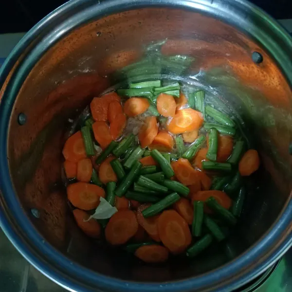 Masukkan air kemudian wortel dan buncis, masak sebentar.