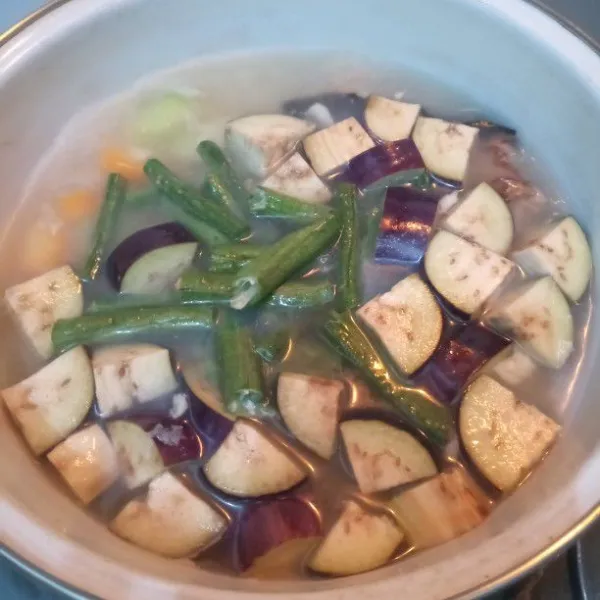 Kemudian, tambahkan kacang panjang dan terong ungu. Masak hingga semua sayuran empuk.
