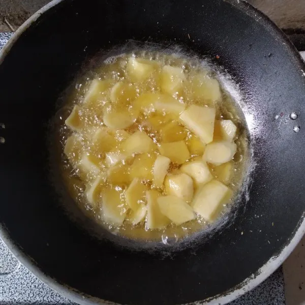 Kupas dan potong kentang sesuai selera, kemudian goreng hingga matang, tiriskan.