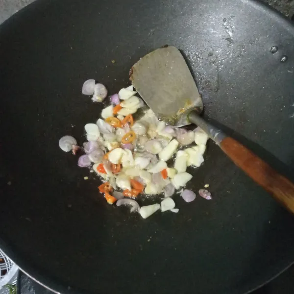 Panaskan minyak, tumis bawang putih, bawang merah, dan cabai rawit hingga harum.