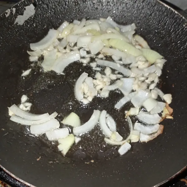 Tumis bawang bombay dan bawang putih hingga layu.