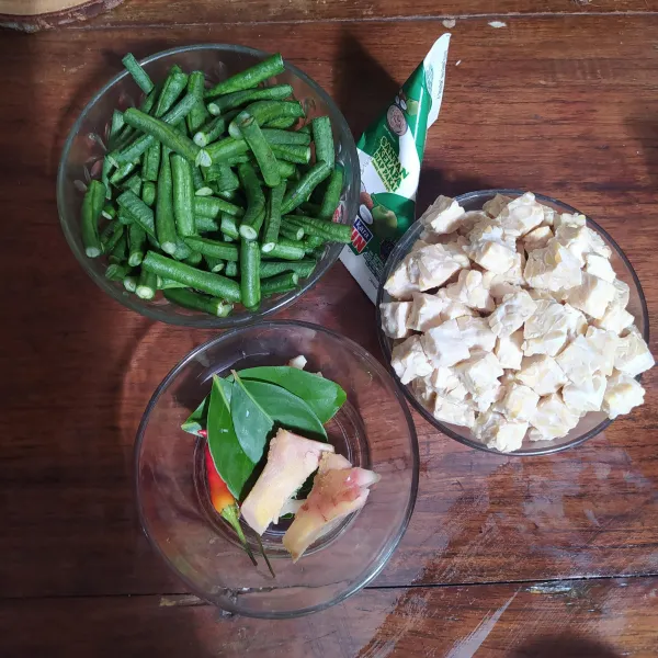 Potong-potong kacang panjang, potong dadu tempe, dan siapkan santan instan, lengkuas geprek, daun salam dan cabe rawit.