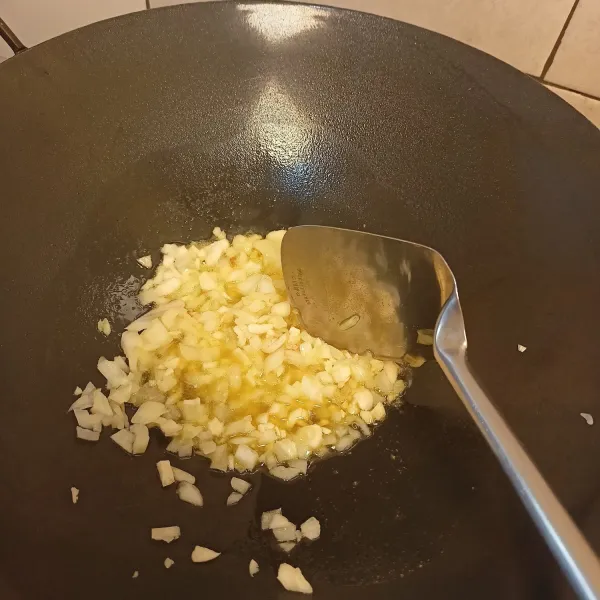 Tumis bawang bombay dan bawang putih sampai layu.