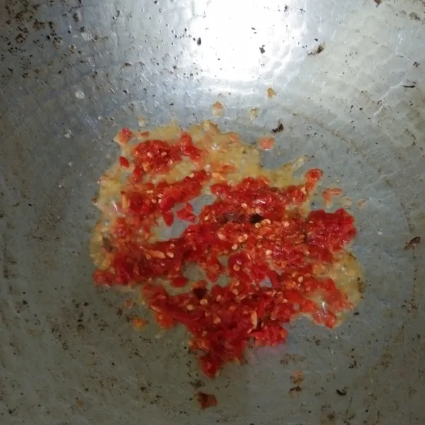Haluskan cabe merah keriting dan bawang putih, kemudian tumis bumbu dengan minyak secukupnya hingga harum