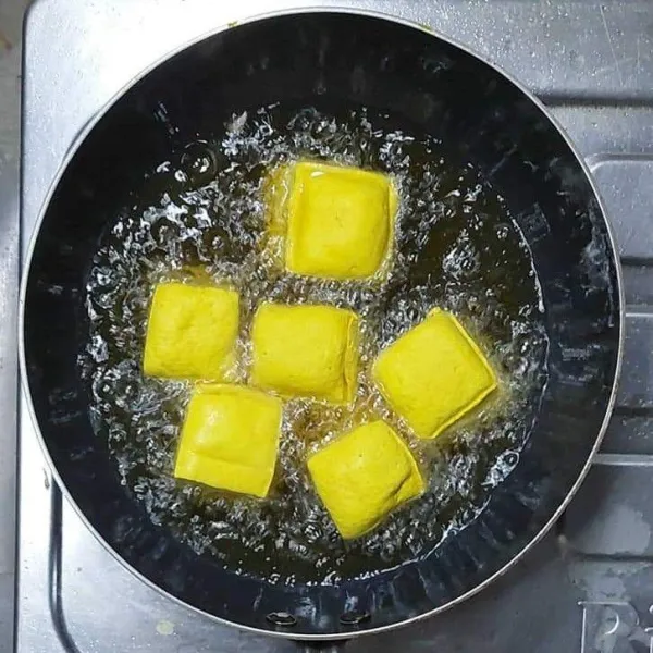 Panaskan minyak, goreng tahu sampai matang. Angkat dan tiriskan, lalu potong-potong dan sisihkan.