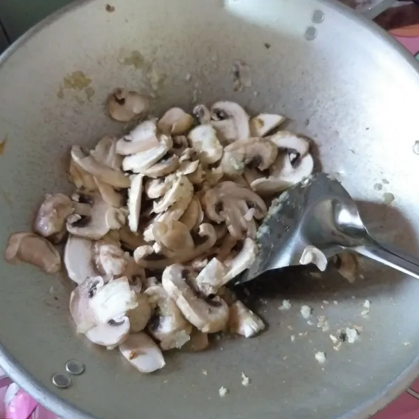 Siapkan irisan bawang bombai, bawang putih, dan jahe. Panaskan minyak kemudian tumis bawang hingga harum, dan masukkan jamur kancing aduk sebentar.